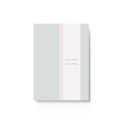 light grey hardcover journal notebook with light pink and white vertical stripe. the words, one step at a time