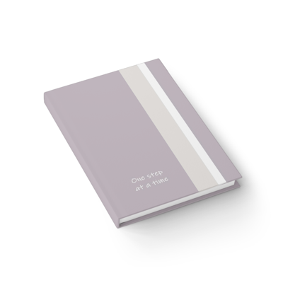 netural beige with lighter beige and white vertical stripe, hardcover journal notebook with the words, one step at a time. vertical diamond shapes in lighter pink.