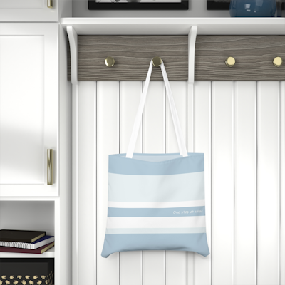 blue and white striped tote bag with the words, one step at a time. white handles