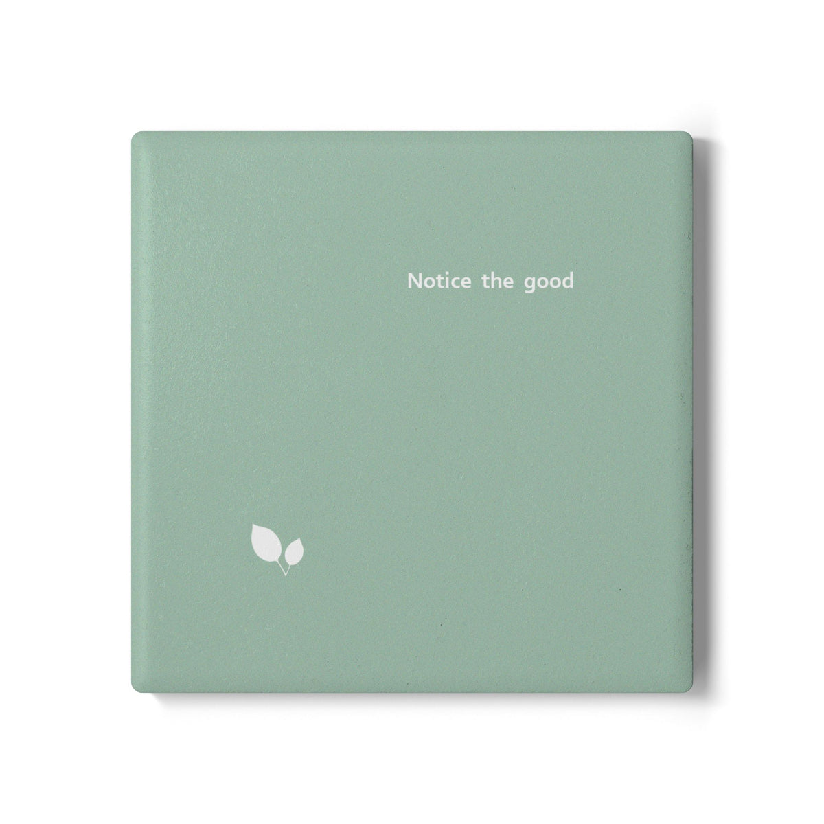 Green square ceramic coaster with delicate leaf motif design, and small, modern style text ‘Notice the good’ in white font.