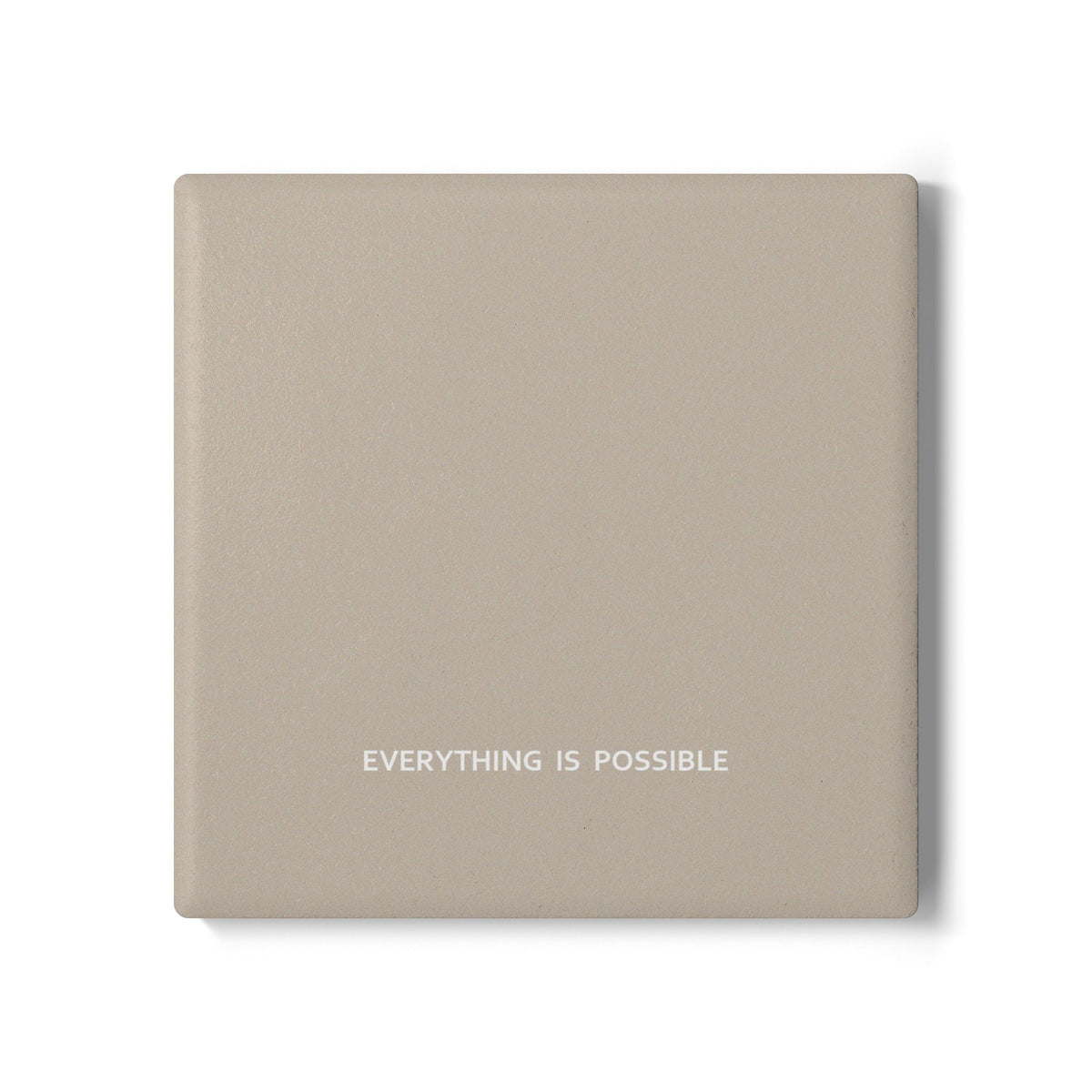 Beige square ceramic coaster with modern style text ‘Everything is possible’ in white font.