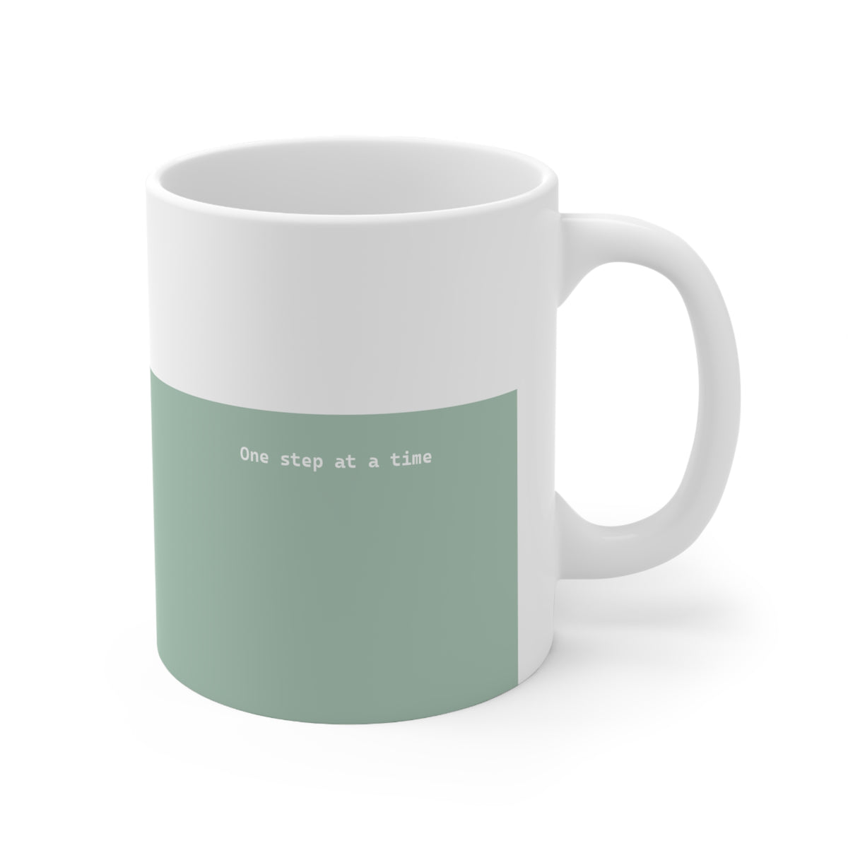 Right side view of green and white ceramic minimalist mug, 11oz size, showing ‘One step at a time’ text and handle