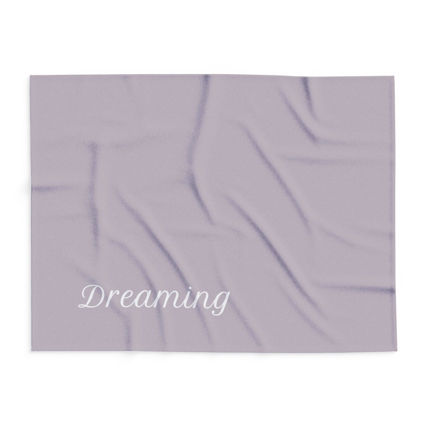 Brown blanket with large, elegant font in white for the text ‘Dreaming'