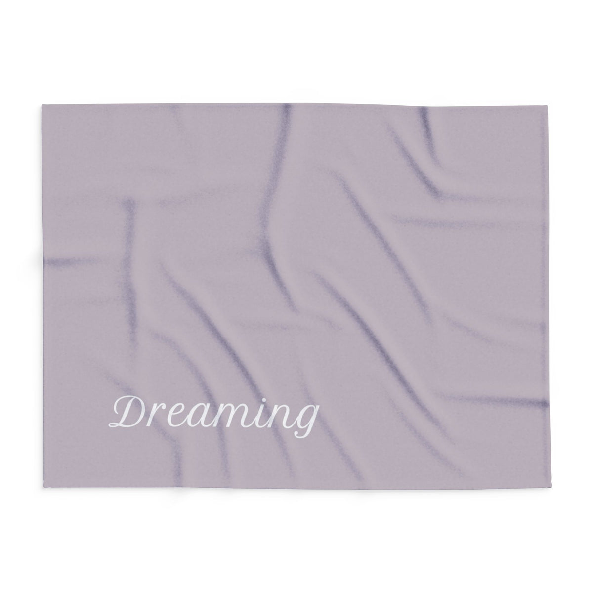Brown blanket with large, elegant font in white for the text ‘Dreaming'