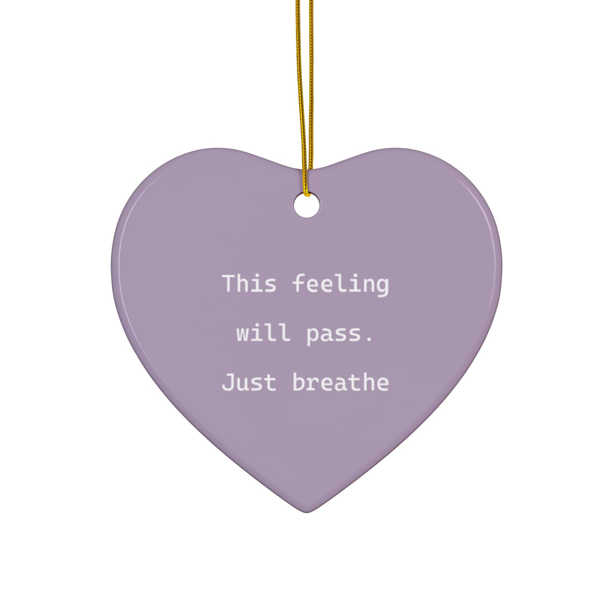 A heart-shaped lavender ceramic ornament with the text 'This feeling will pass. Just breathe' in white lowercase letters, hanging from a gold string against a plain white background.