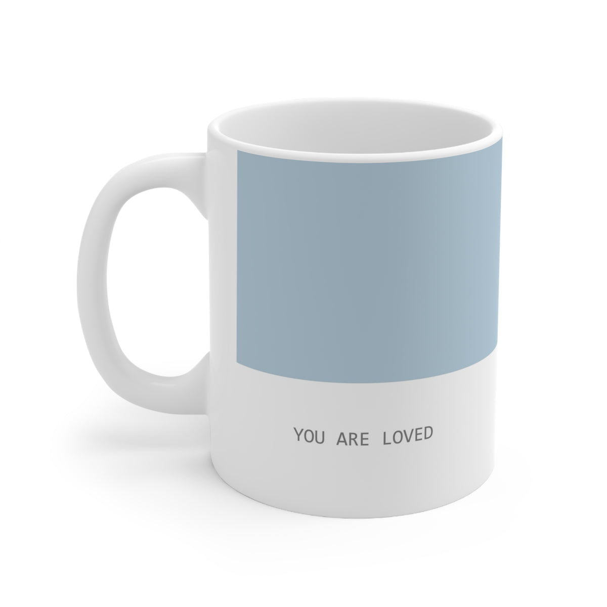 Left side view of blue and white ceramic minimalist mug, 11oz size, showing ‘you are loved’ text and handle