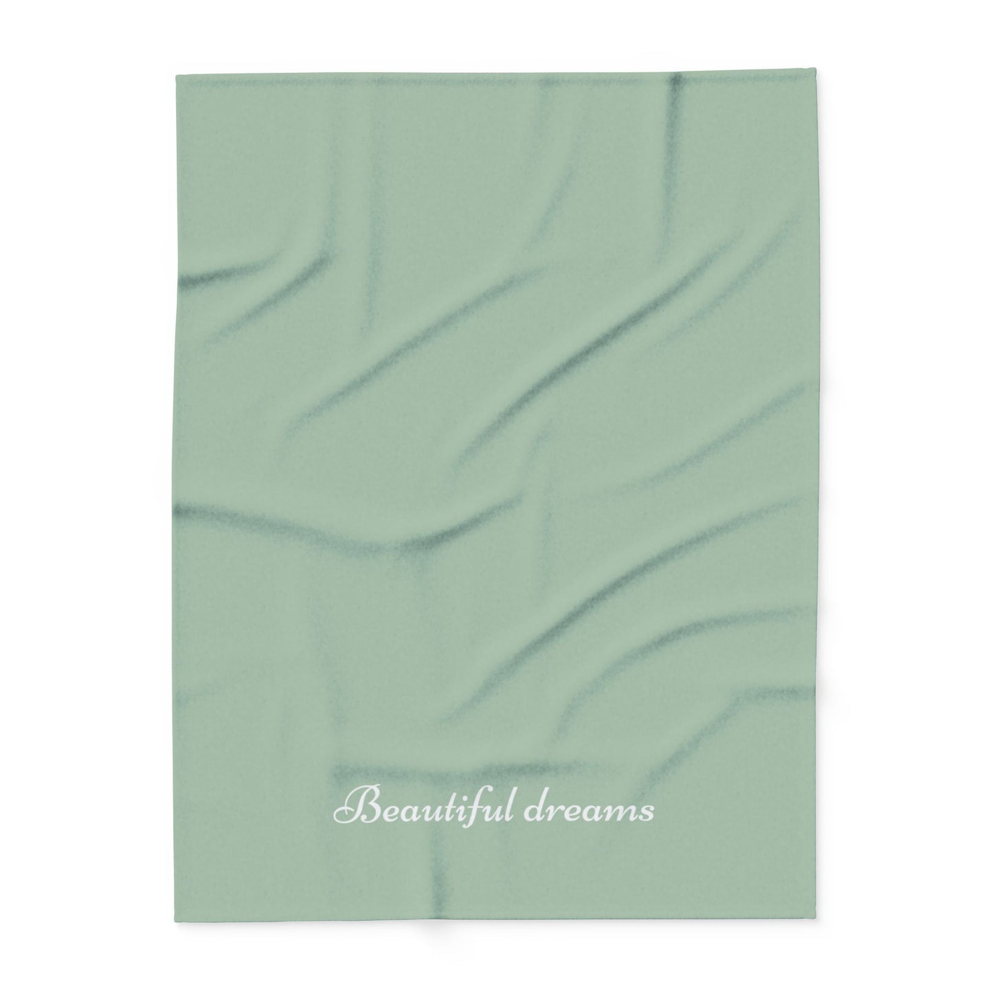 Green blanket with elegant font in white for the text ‘Beautiful dreams’ along the bottom.