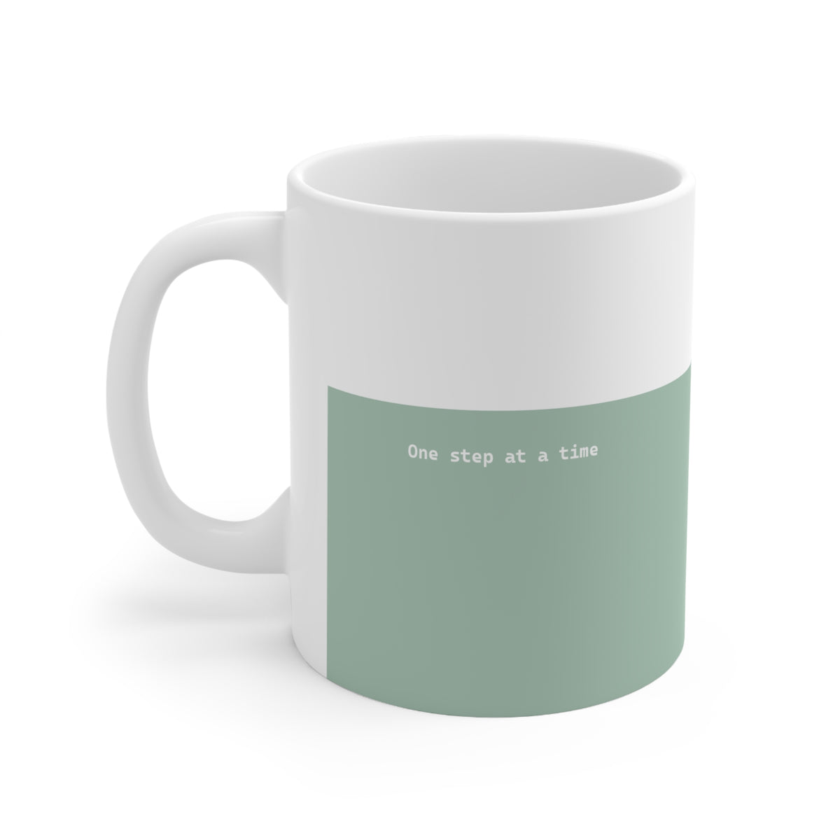 Left side view of green and white ceramic minimalist mug, 11oz size, showing ‘One step at a time’ text and handle