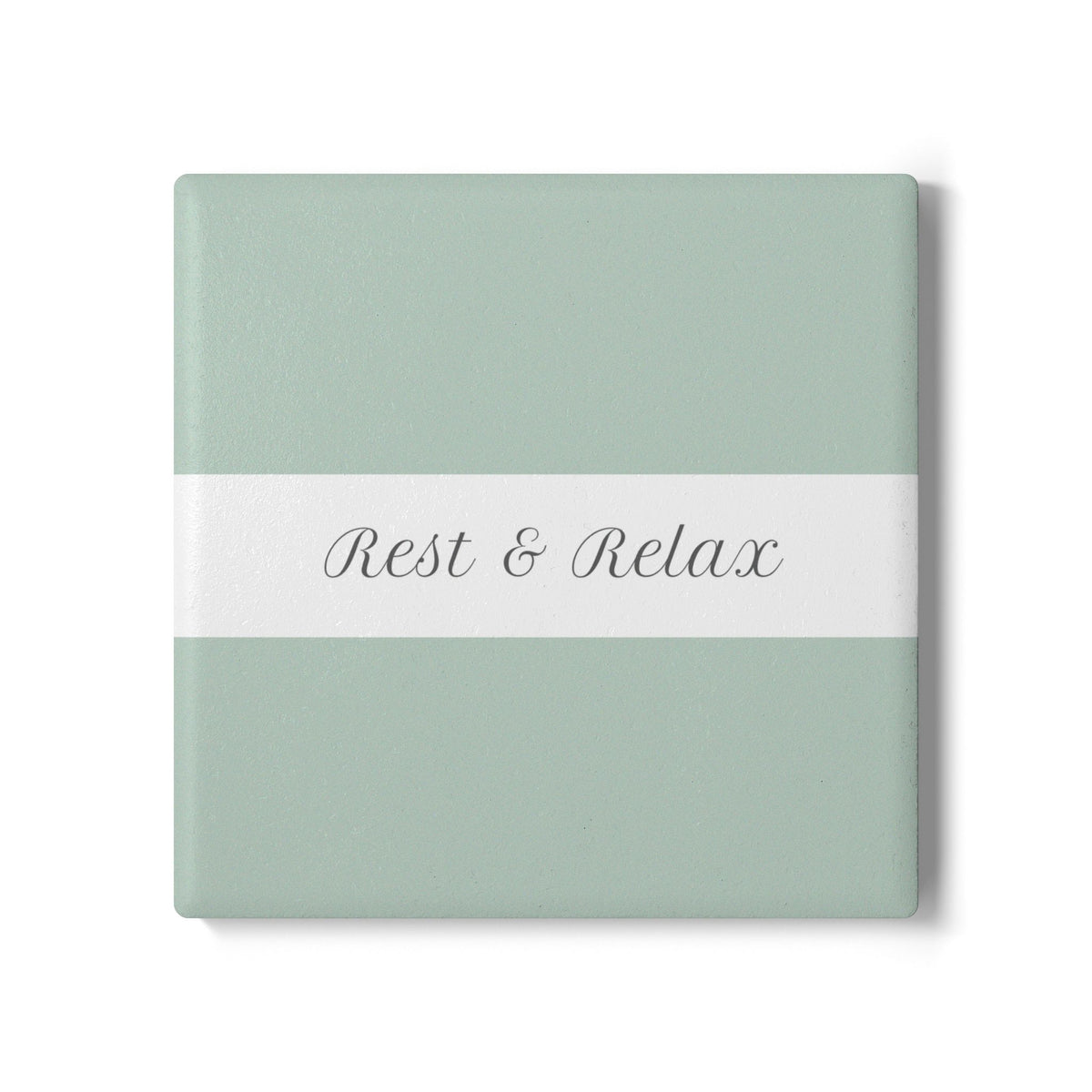 A square coaster with a sage green background, a white horizontal band across the center, and the words 'Rest & Relax' written in gray script.