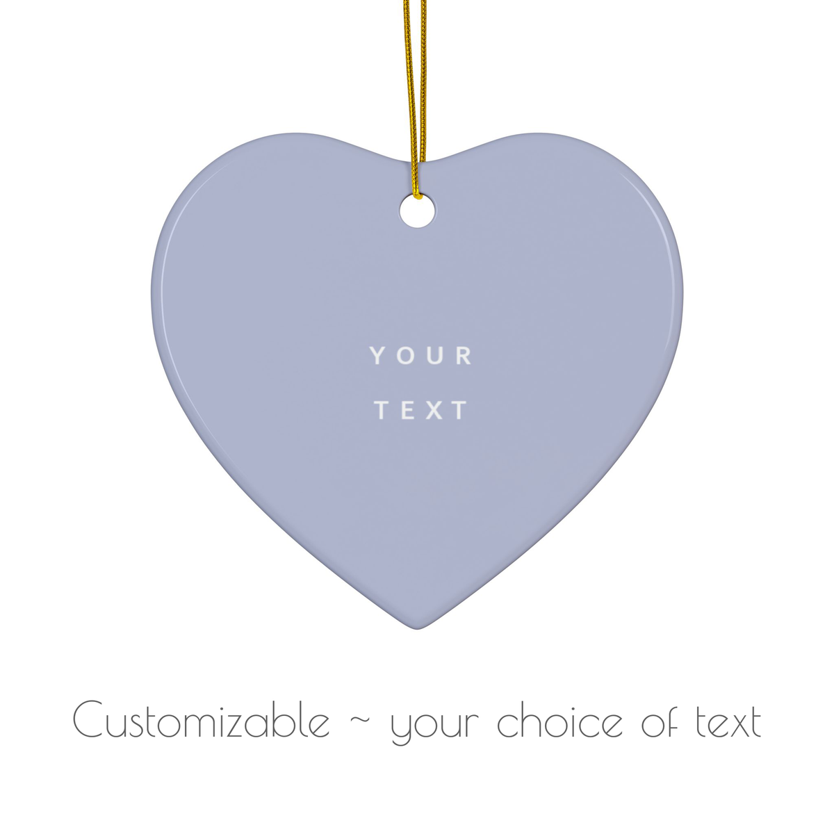 A heart-shaped hanging ornament in a pale lavender-gray color with a gold hanging string and customizable white text in the center, shown on a white background with text below stating 'Customizable ~ your choice of text'.