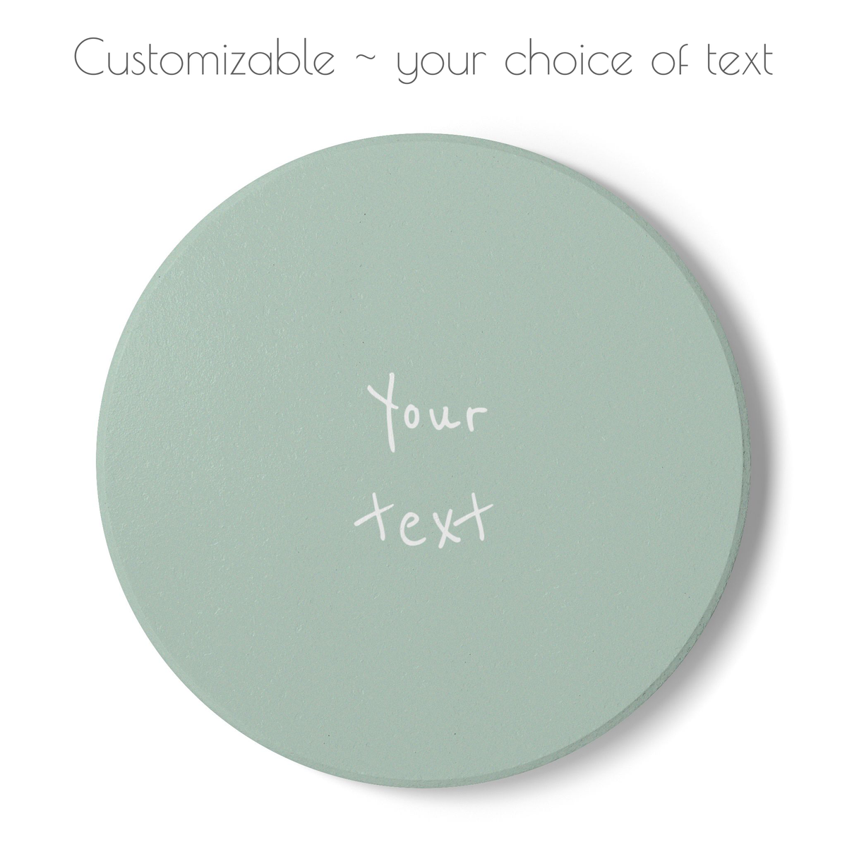 A round, light green coaster with customizable white text in the center, shown on a white background with a soft drop shadow. Text at the top reads 'Customizable ~ your choice of text'.