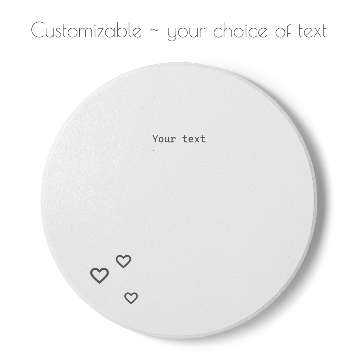 A round white coaster with customizable text and small black outlined hearts, shown on a white background with the text 'Customizable ~ your choice of text' above it.