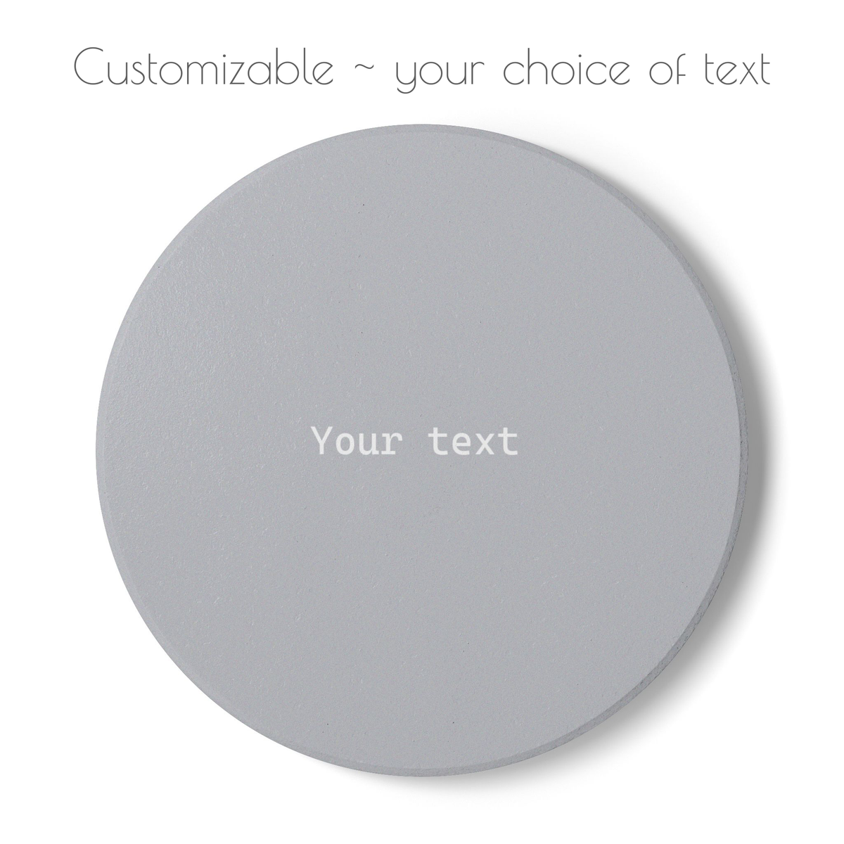 A round gray customizable coaster on a white background, with placeholder text 'Your text' in the center and 'Customizable ~ your choice of text' written above.