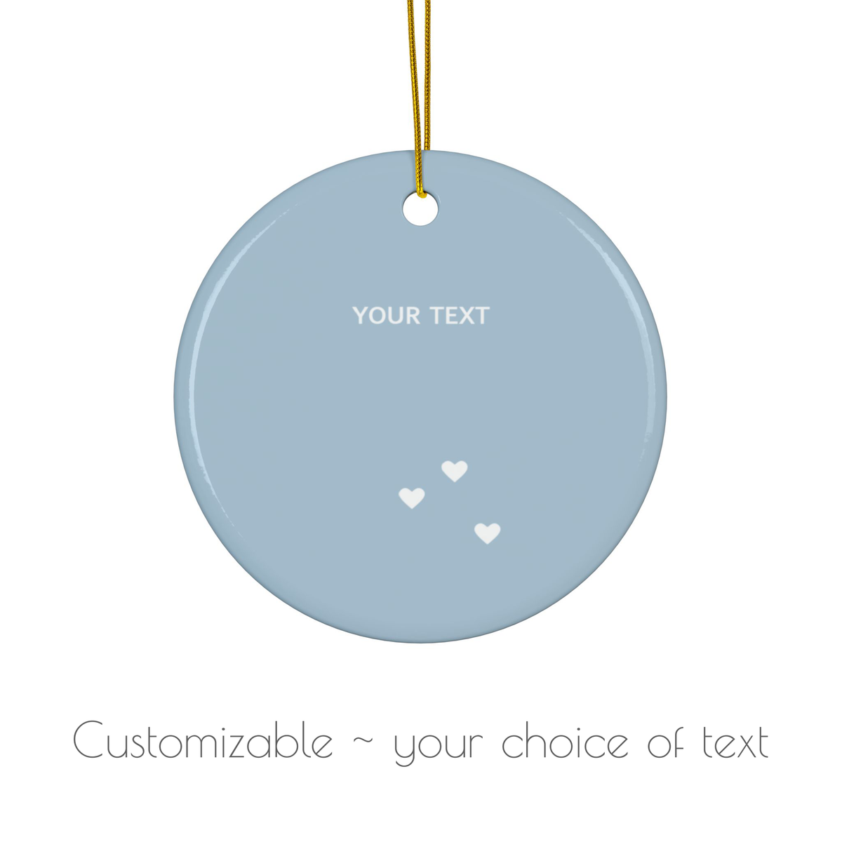 A round light blue hanging ornament with a gold string, featuring the placeholder text 'YOUR TEXT' and three small white hearts, shown on a white background with the text 'Customizable ~ your choice of text' below.