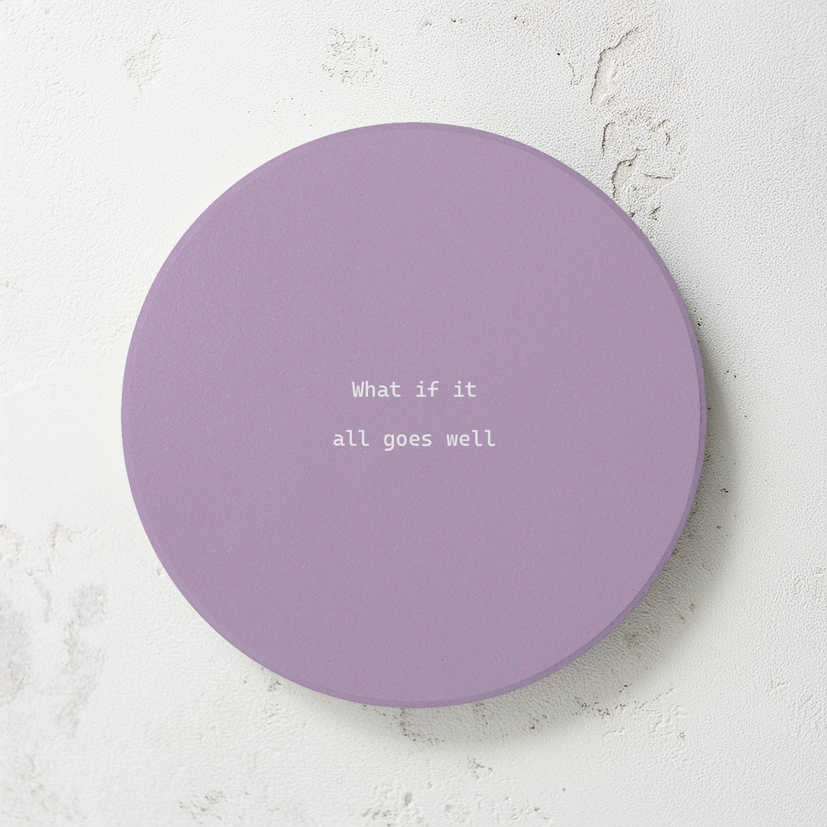 Purple round ceramic coaster with modern style text ‘What if it all goes well’ in white font. The coaster is on a  cement style surface.
