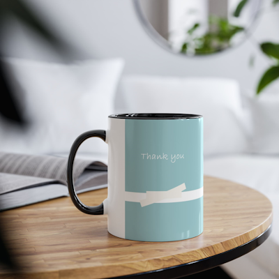 teal ceramic mug with white bow design and the words, Thank you. black handle and black inside.