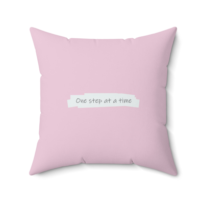 pink square decorative pillow with words, one step at a time.