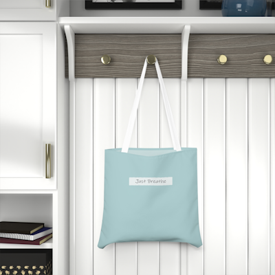blue tote bag with the words, just breathe. white handles
