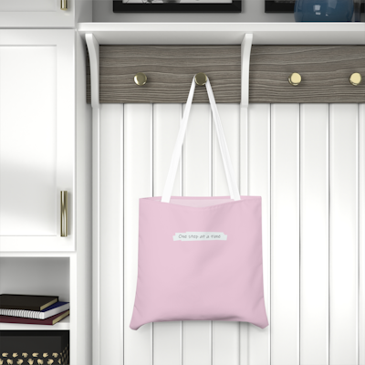 pink tote bag with the words, one step at a time. white handles